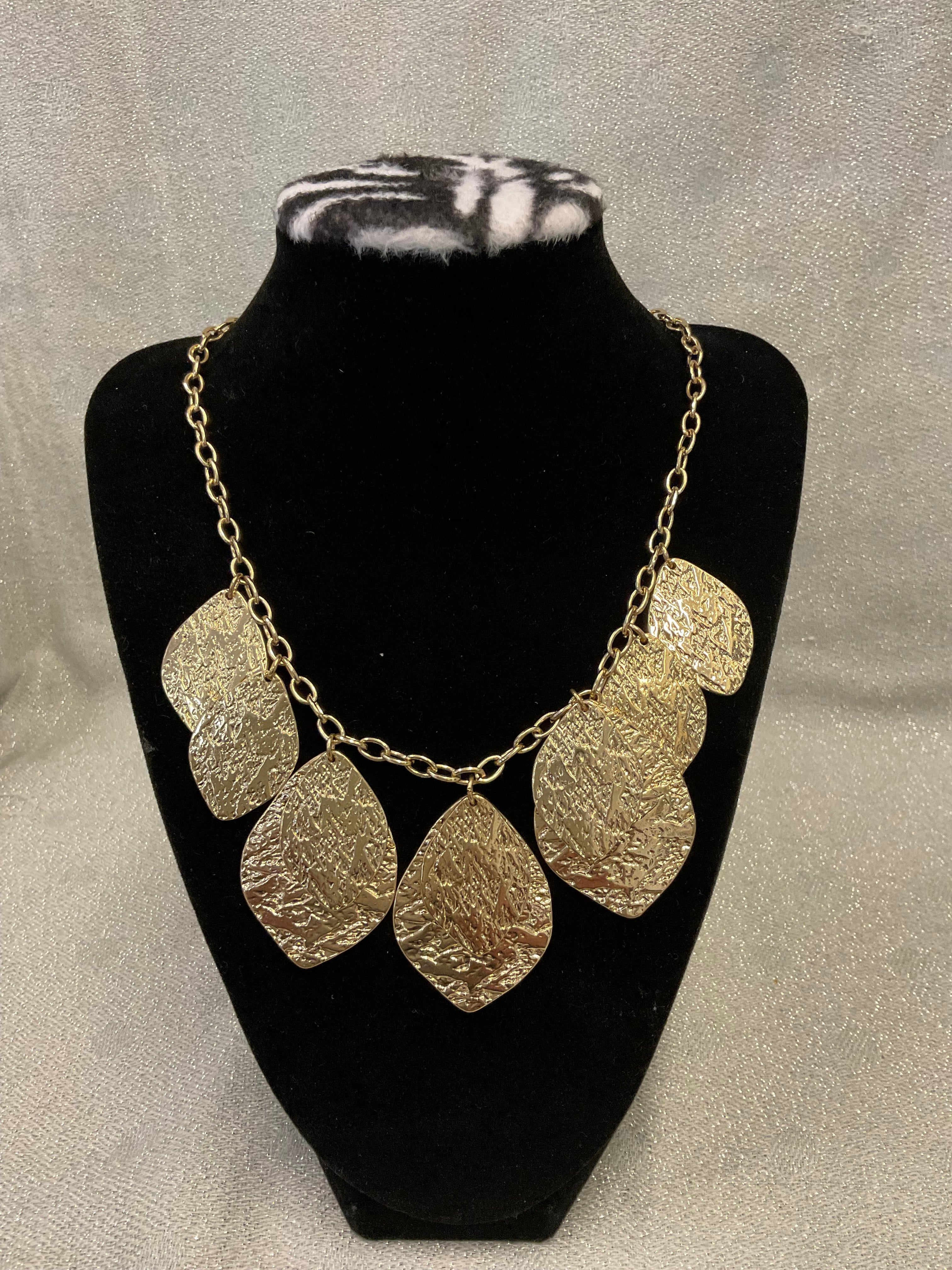Gold toned fashion necklace with hammered leaf shaped pendants