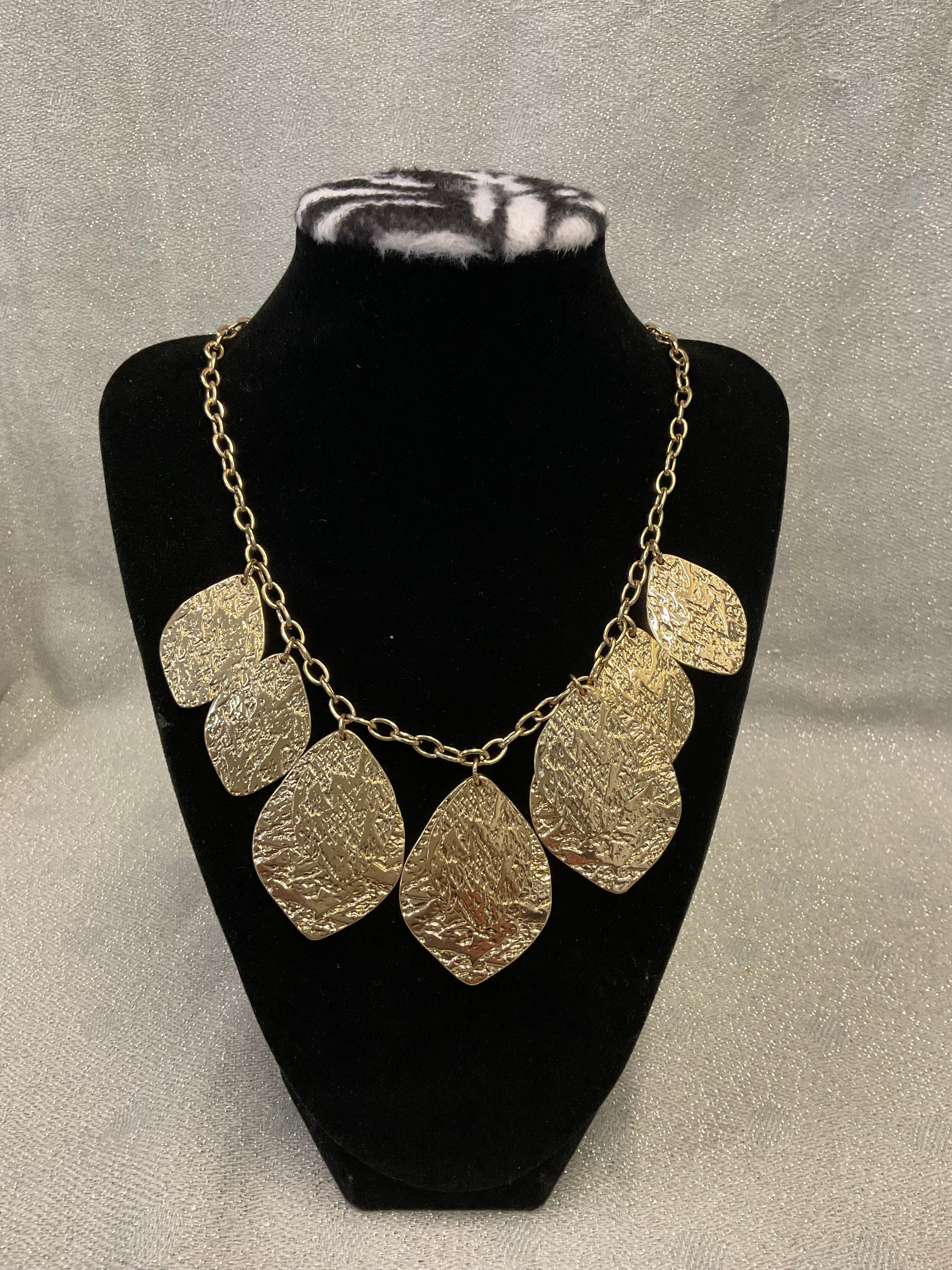 Gold toned fashion necklace with hammered leaf shaped pendants