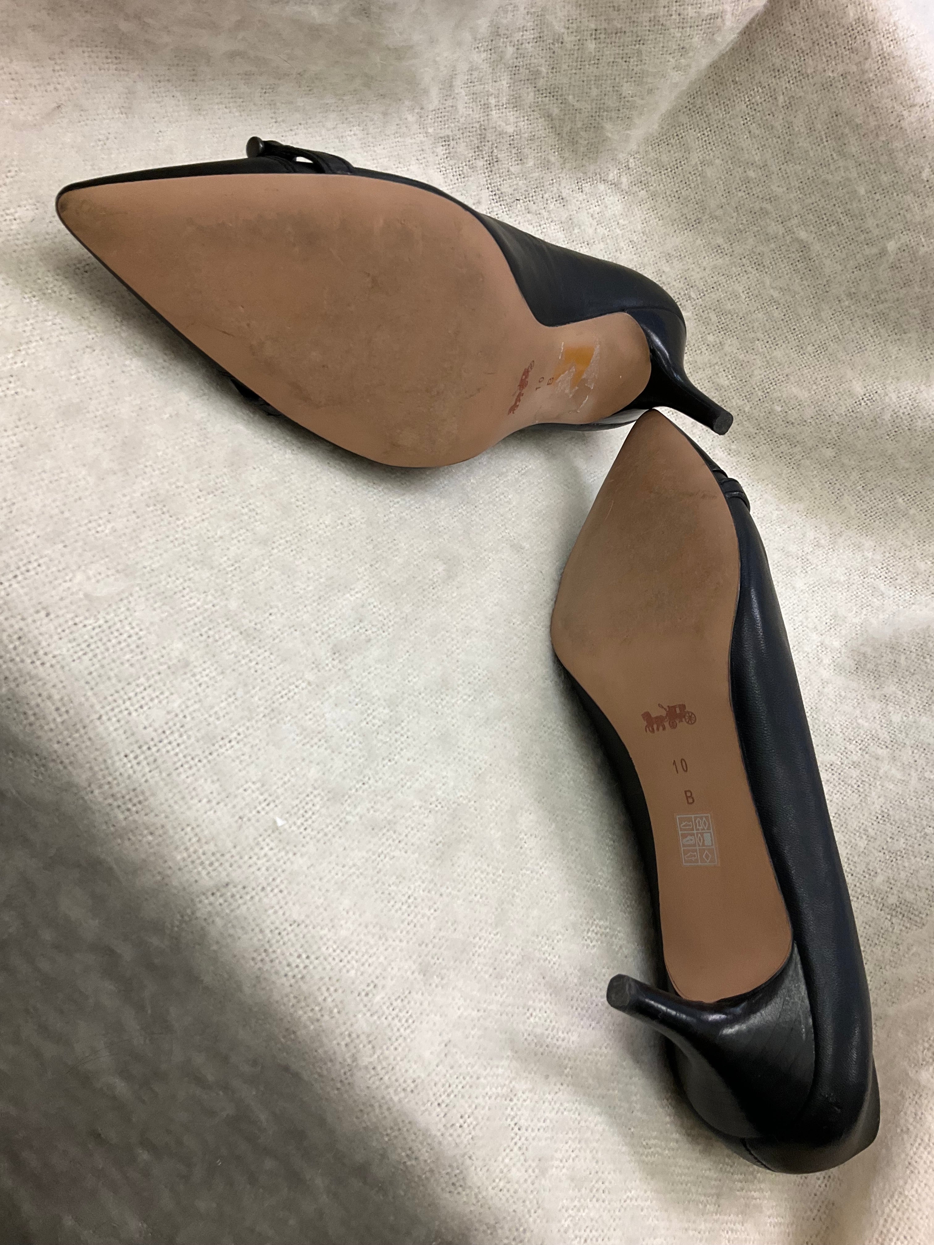 Coach Stylish black Coach pointed toe heels. Has silver-tone horsebit detail on front. Kitten heels. Size 10B.